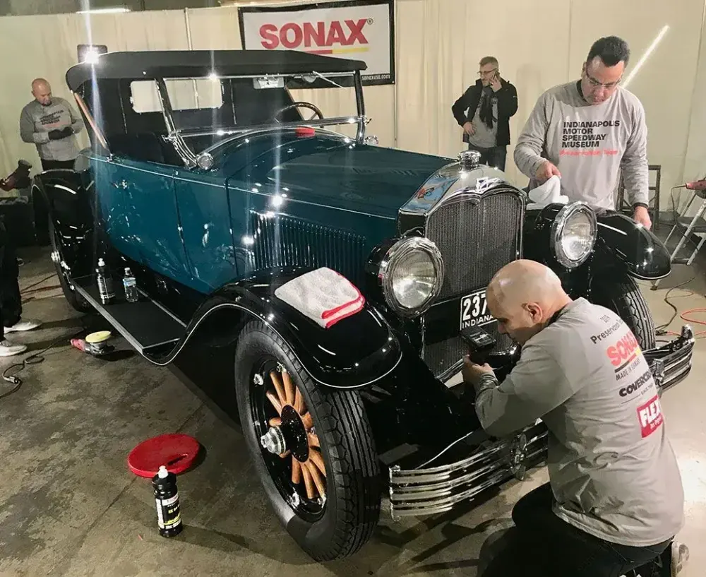 Rear three-quarter of a classic car restored to a deep gloss
